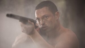 maori man aiming long barreled shot gun